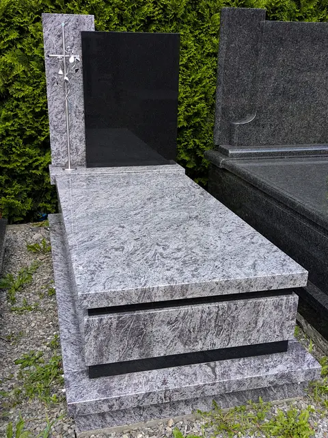 Nowoczesny nagrobek pojedynczy z granitów "Orion" i "Warangal" z czarną tablicą, stojącym krzyżem nierdzewnym oraz wykończeniem w kantach