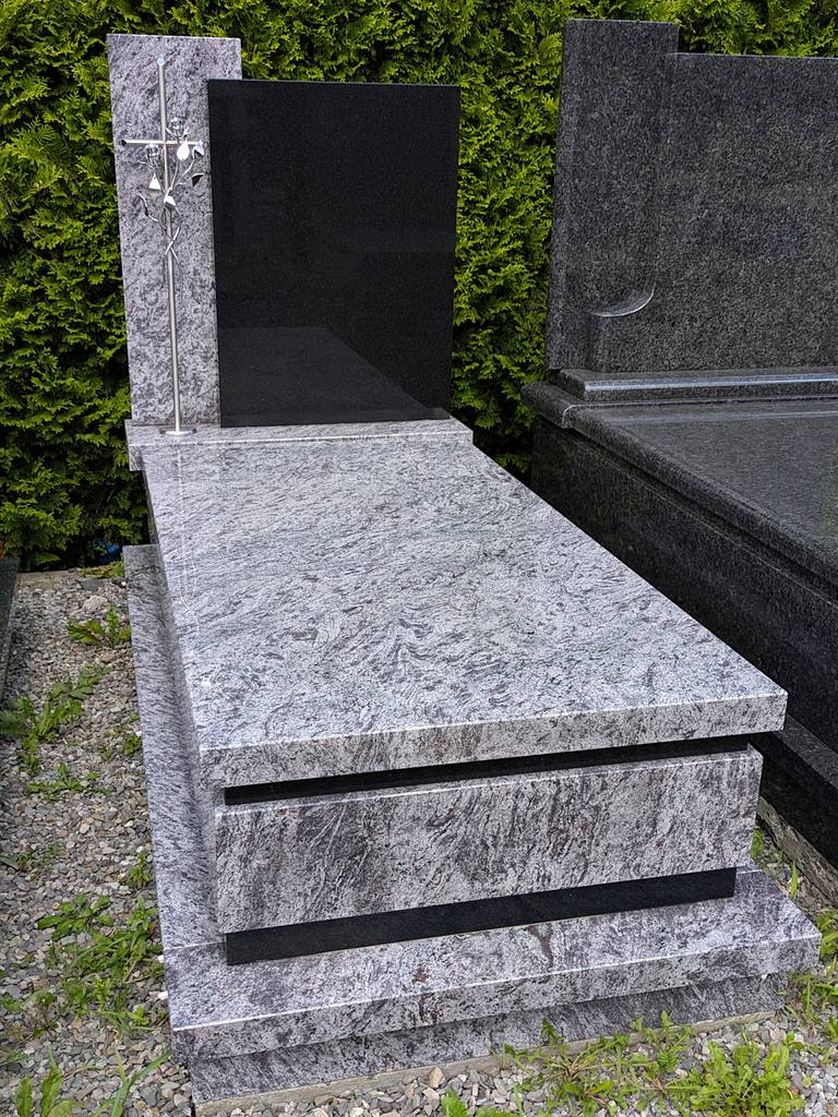 Nowoczesny nagrobek pojedynczy z granitów "Orion" i "Warangal" z czarną tablicą, stojącym krzyżem nierdzewnym oraz wykończeniem w kantach