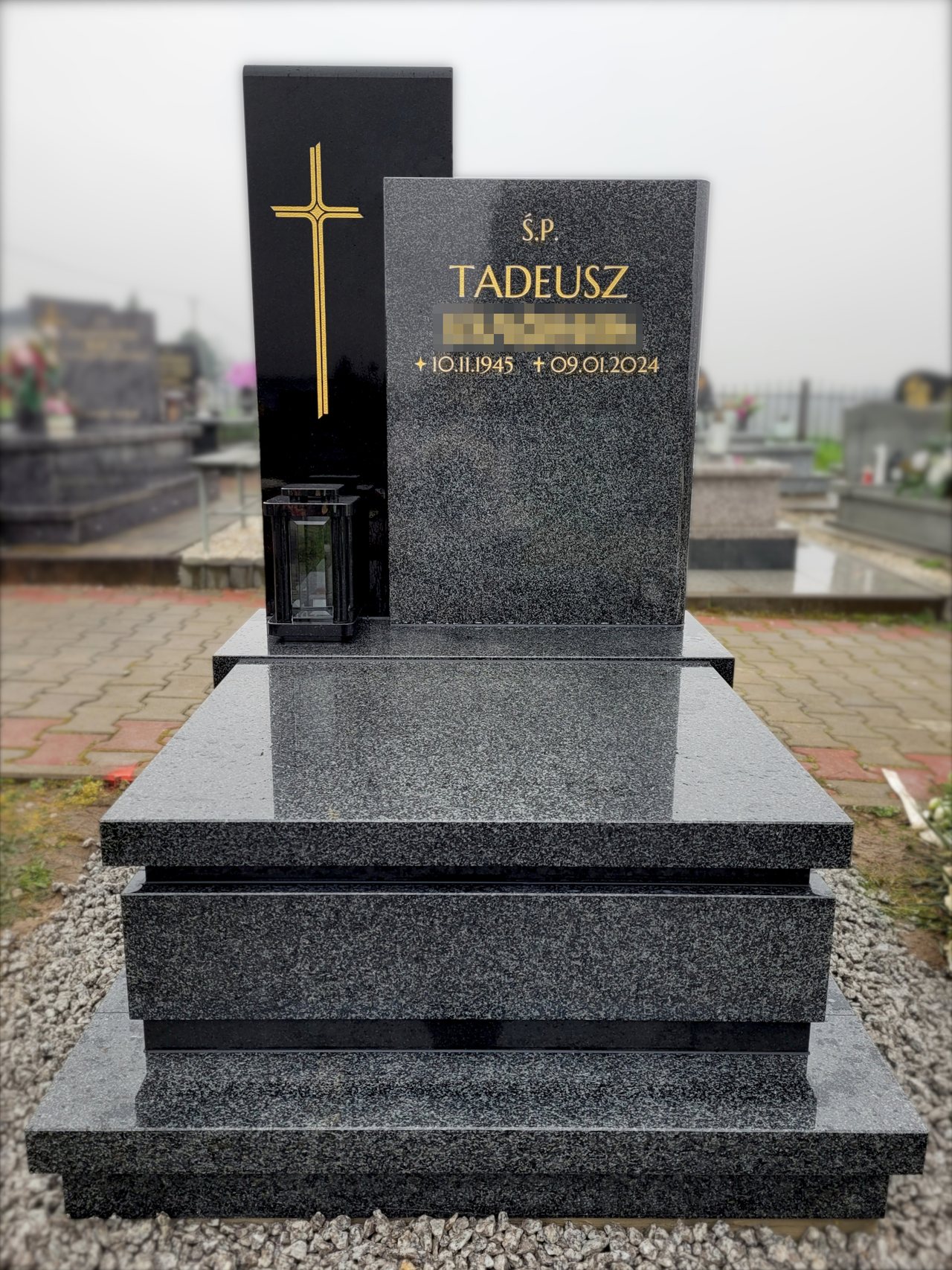 Nagrobek urnowy z kamienia "Impala" i czarnego granitu z kamienną latarką