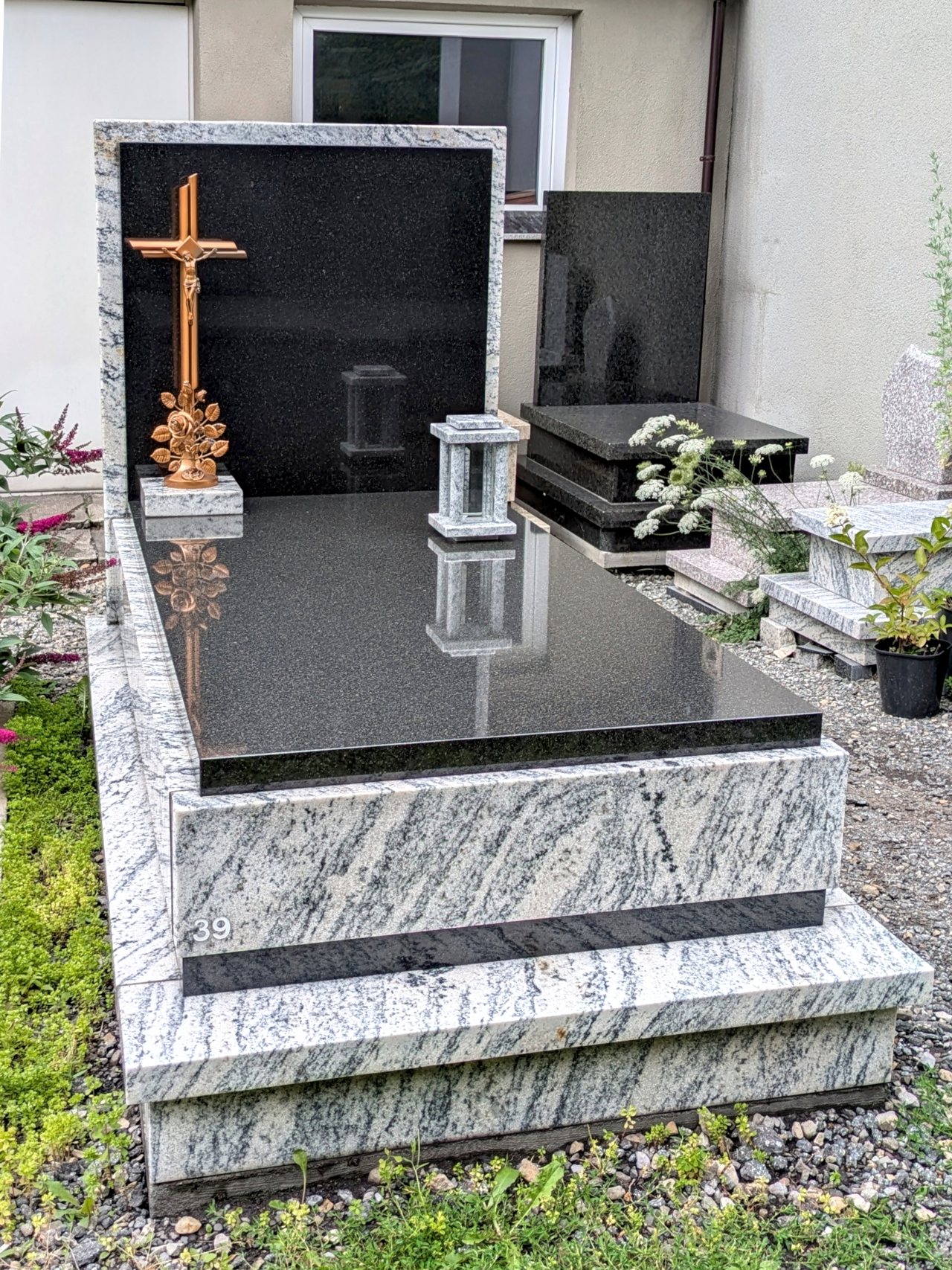 Nowoczesny nagrobek pojedynczy z granitu "Viscount White" i "Bengal Black" z mosiężnym stojącym krzyżem oraz kamienną latarką