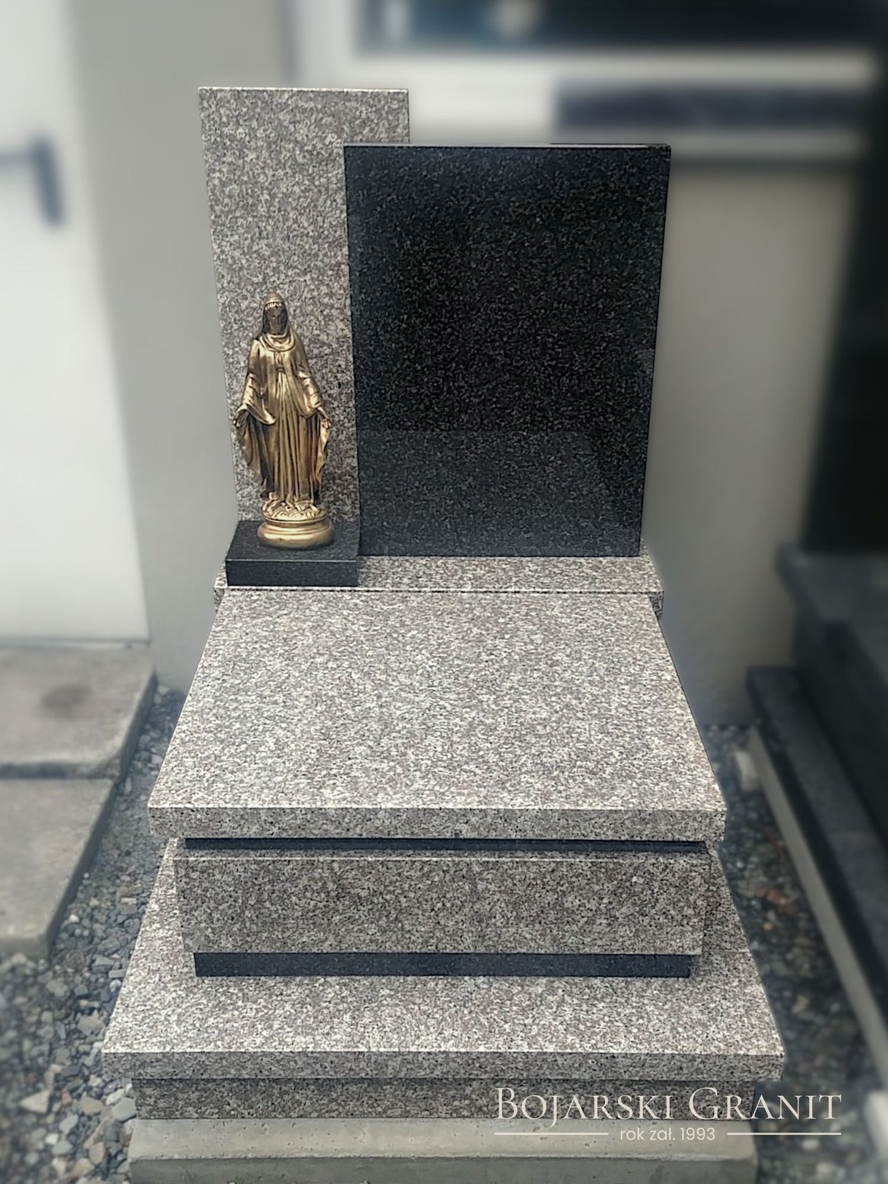 Nagrobek urnowy z granitów "Brąz Królewski" oraz "Impala" z figurą Matki Boskiej