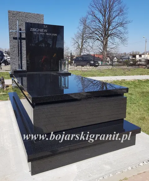 Czarny pomnik. Litery i krzyż z nierdzewki