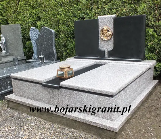 Nagrobek podwójny z granitu jasnego. Tablice symetryczne z granitu czarnego.