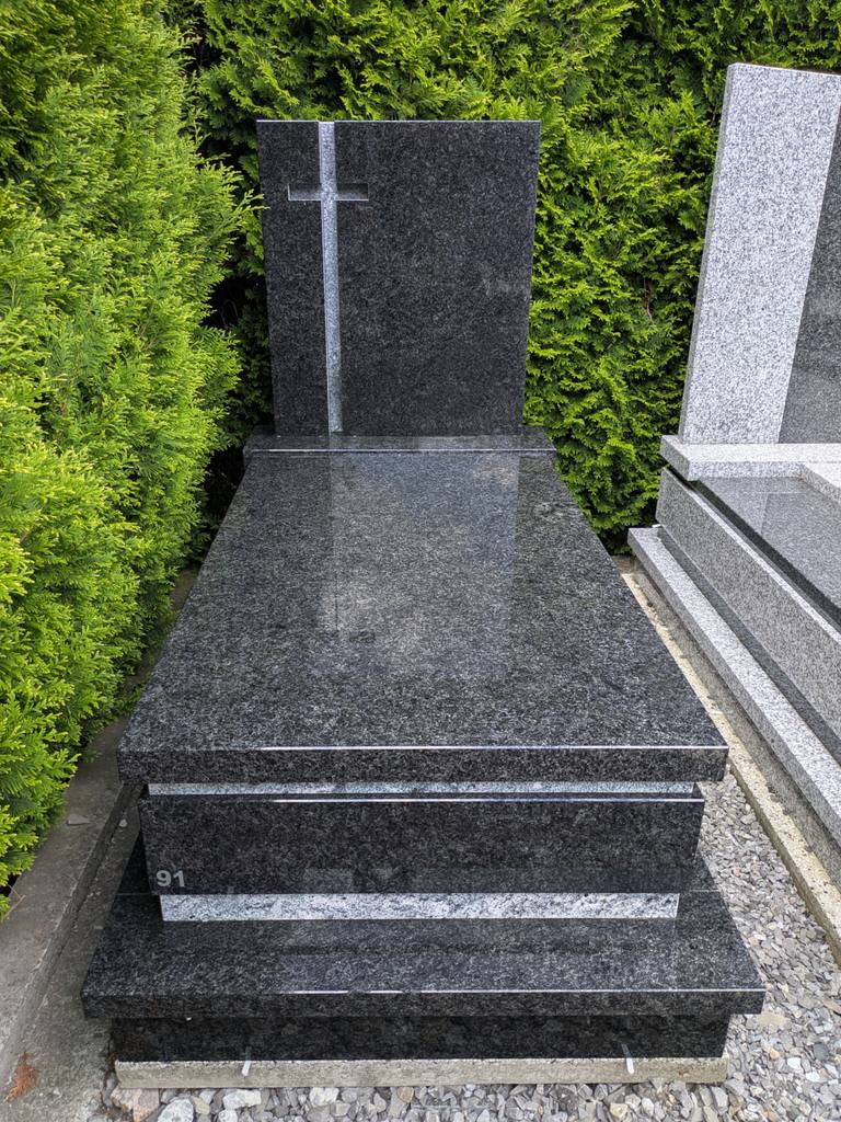 Nowoczesny nagrobek pojedynczy z granitów "Angola" oraz "Viscount White" z motywem krzyża oraz prostym wykończeniem w kantach