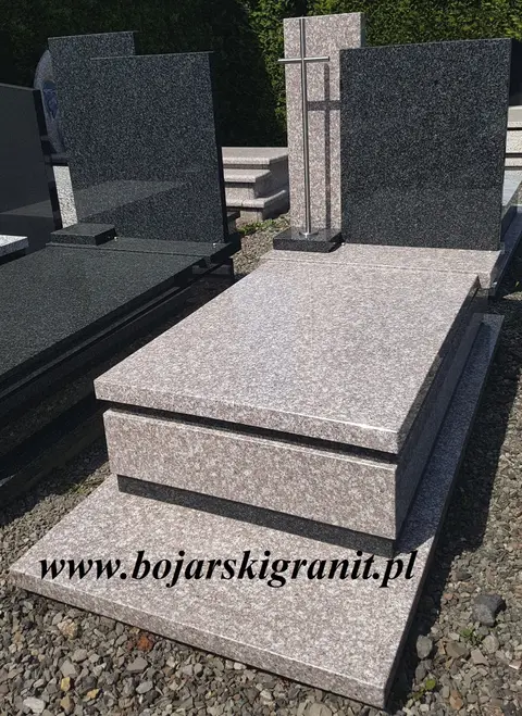 Nagrobek granitowy z ciemną tablicą i ciemnymi paskami ozdobnymi.