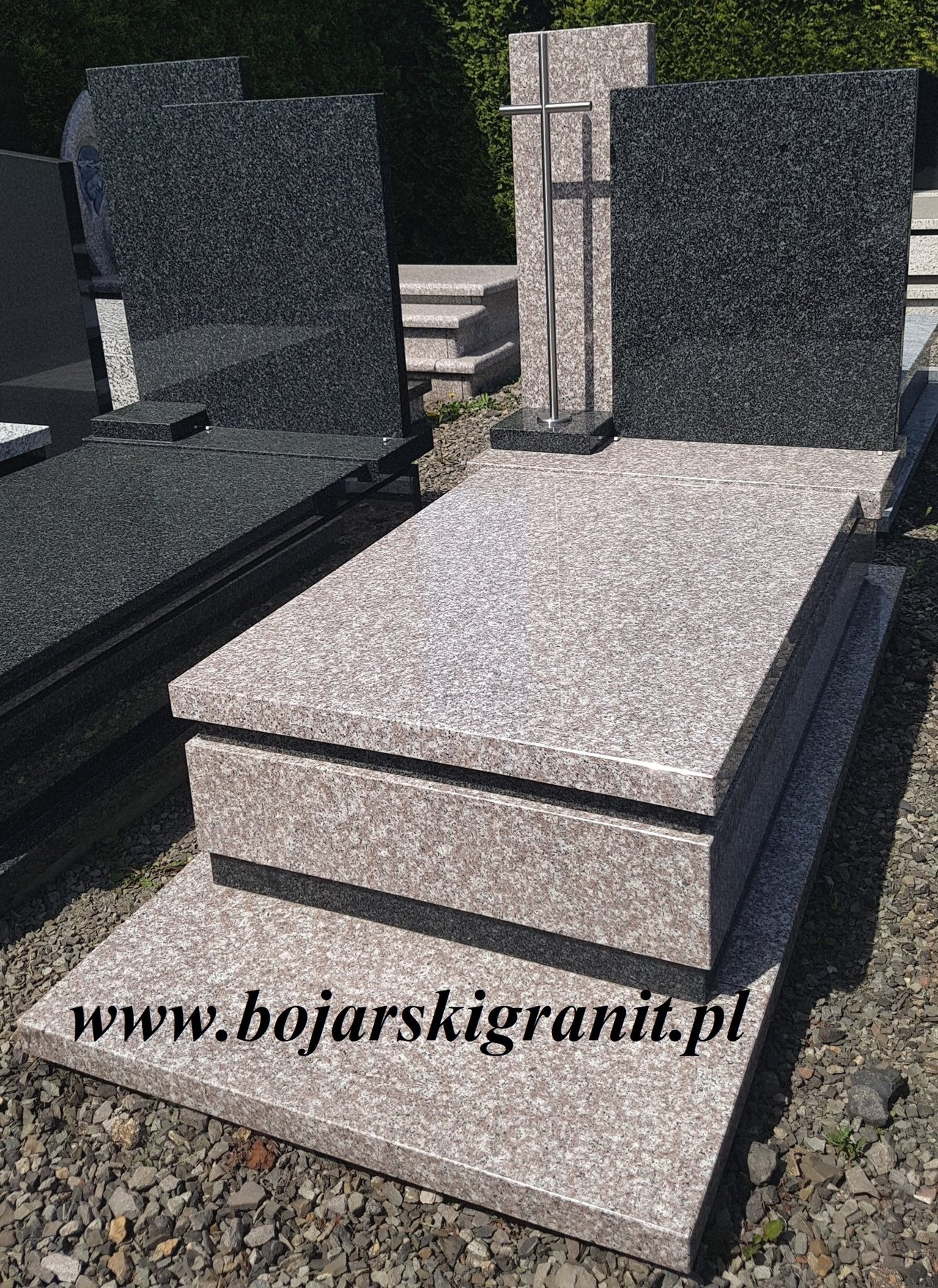 Nagrobek granitowy z ciemną tablicą i ciemnymi paskami ozdobnymi.